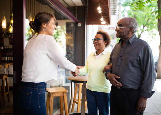 Woman shaking hands with elderly couple Woman shaking hands with elderly couple